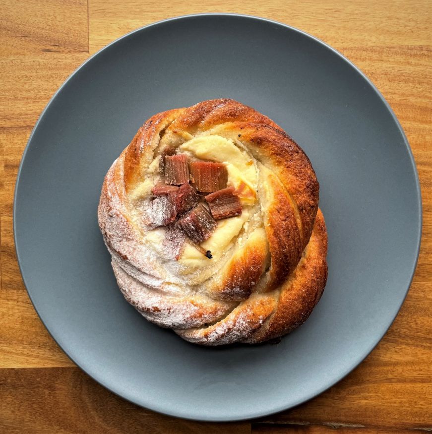 Round pastry with a cream cheese filling topped with rhubarb pieces