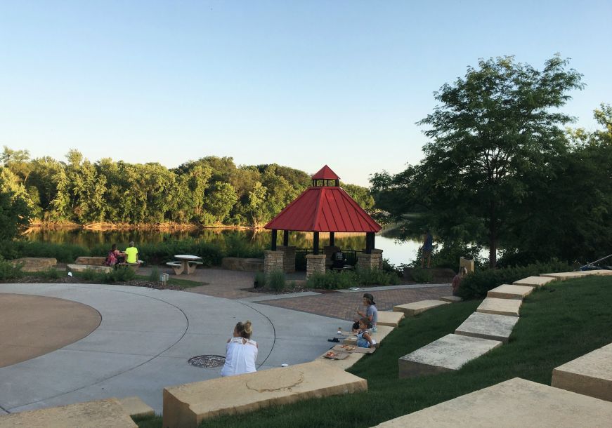 People in a park with gazebo, seating, and Mississippi River in background