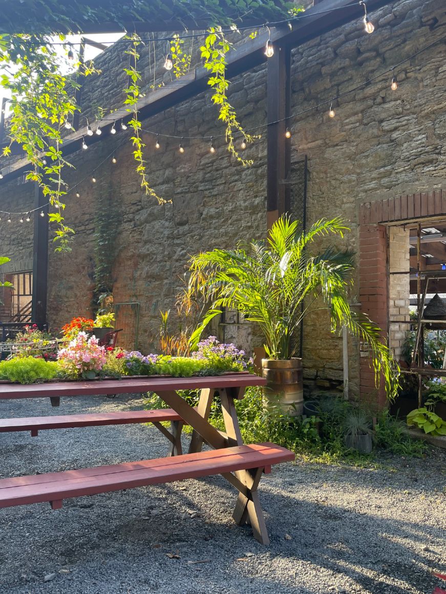 Saint Paul Brewing Picnic table on a patio decorated with fairy lights and greenery