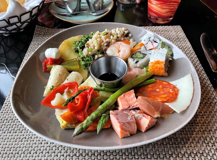 Plate of salads, sushi, cheese, smoked salmon, and other items