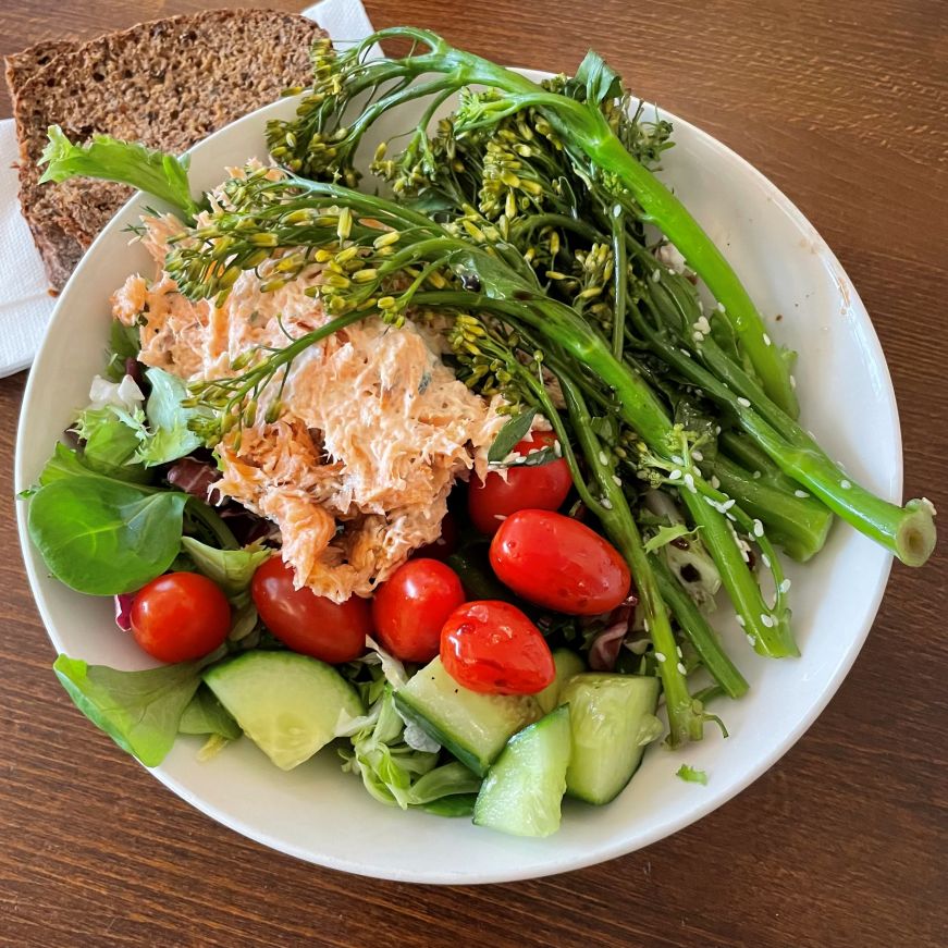 Lettuce salad with salmon, cucumers, tomatoes, and broccolini