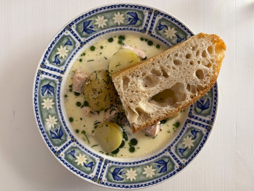 Salmon soup with large piece of potato and a slice of focaccia