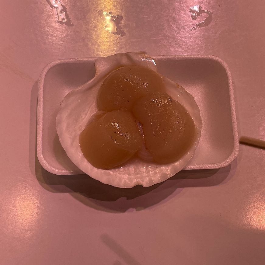 Shell holding three raw scallops