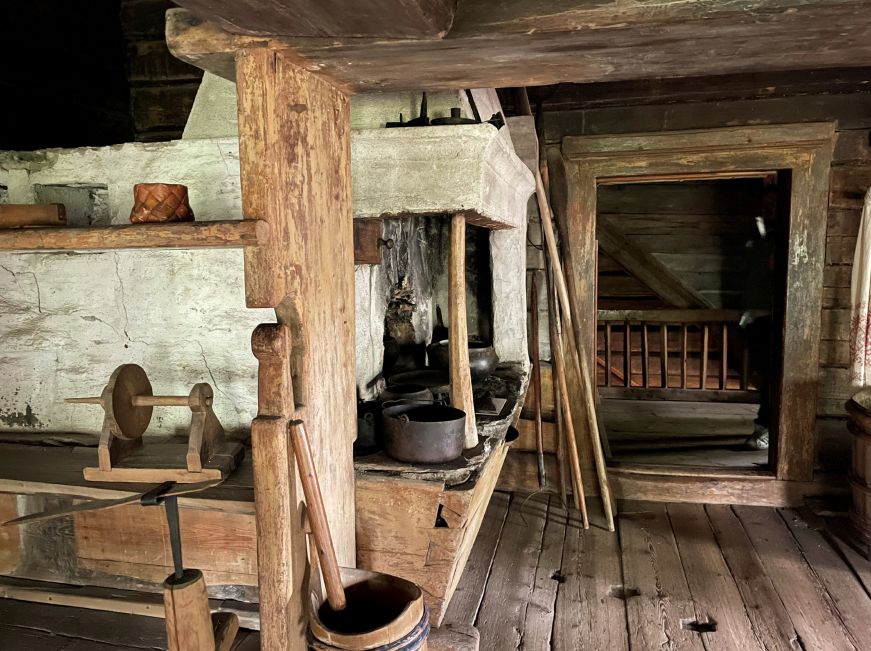 Room inside log cabin with a stone hearth