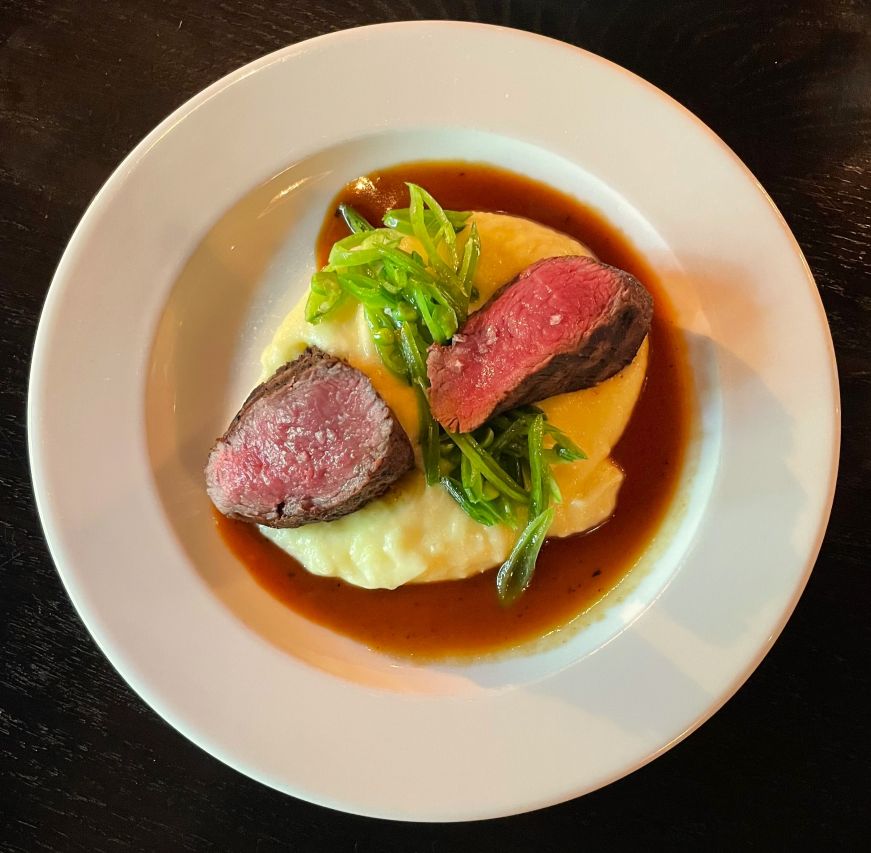 Plate with mashed potatoes and two small pieces of steak