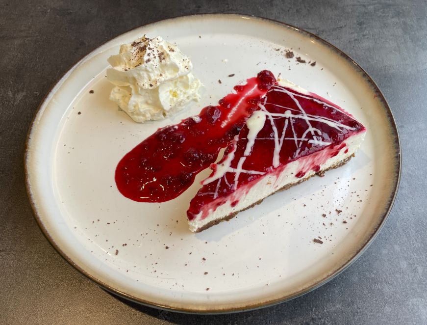 Skyr cake, Maritime Museum Piece of cheesecake with raspberry topping, with a dollop of whipped cream on the side