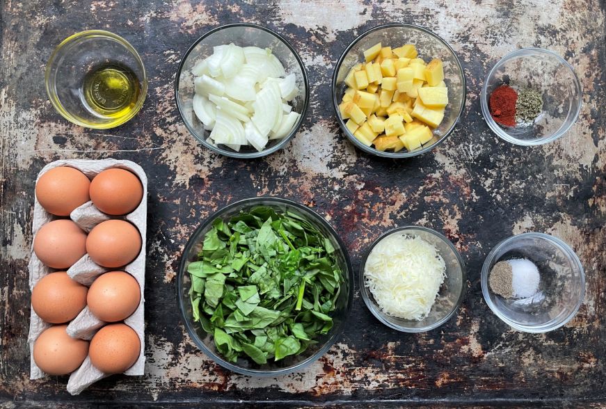 Top down view of baking sheet with tortilla ingredients arranged on it