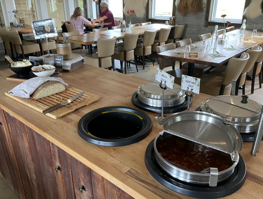 Small buffet with pots of soup and a loaf of bread