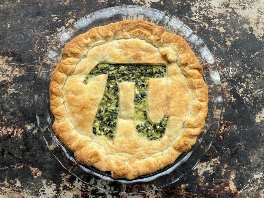 Spinach feta pie with a pi symbol cut out of the top crust
