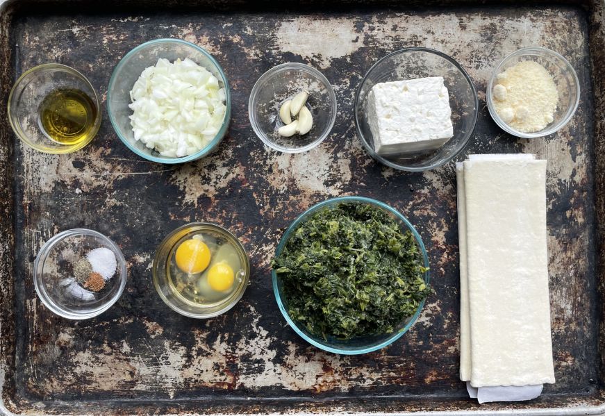 Top down view of a baking sheet with bowls of ingredients 