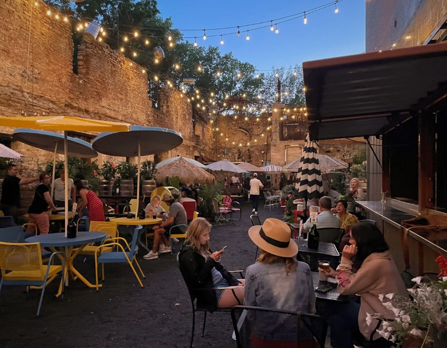 Patio enclosed with a brick wall and lights strung across