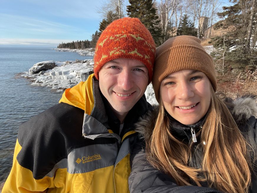 Stacy and Mike wearing winter clothes with Lake Superior in the background