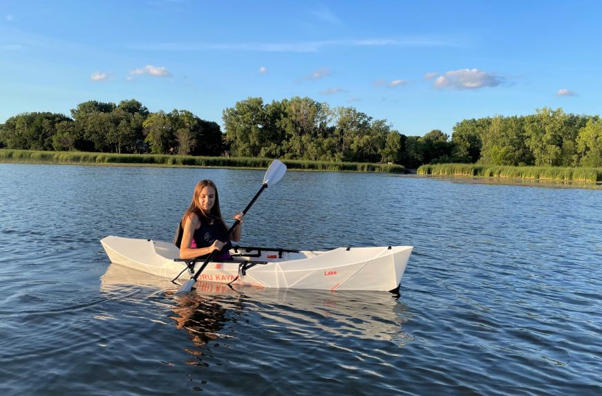 Stacy paddling a kayak on a lake