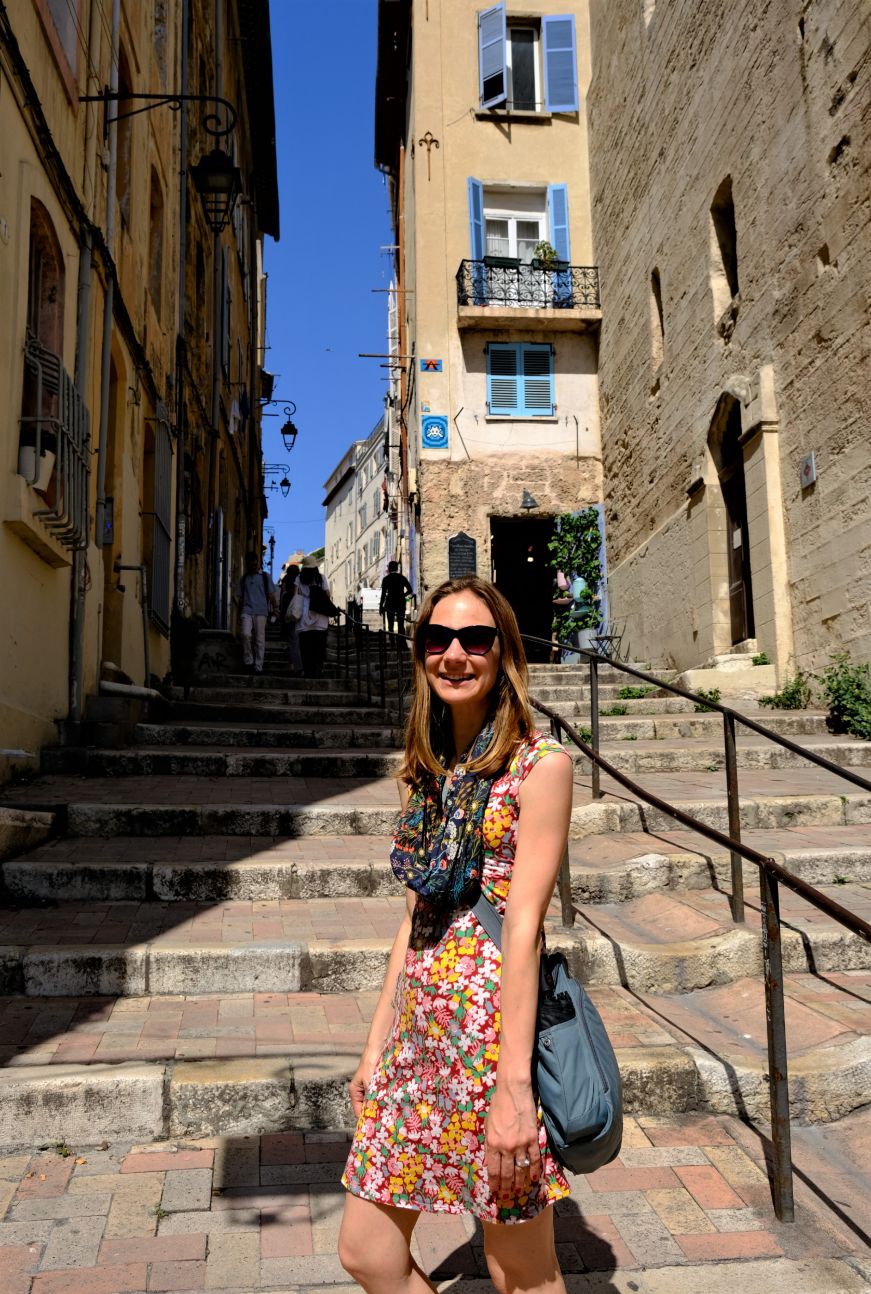 Stacy on a steep stone staircase with buildings on either side