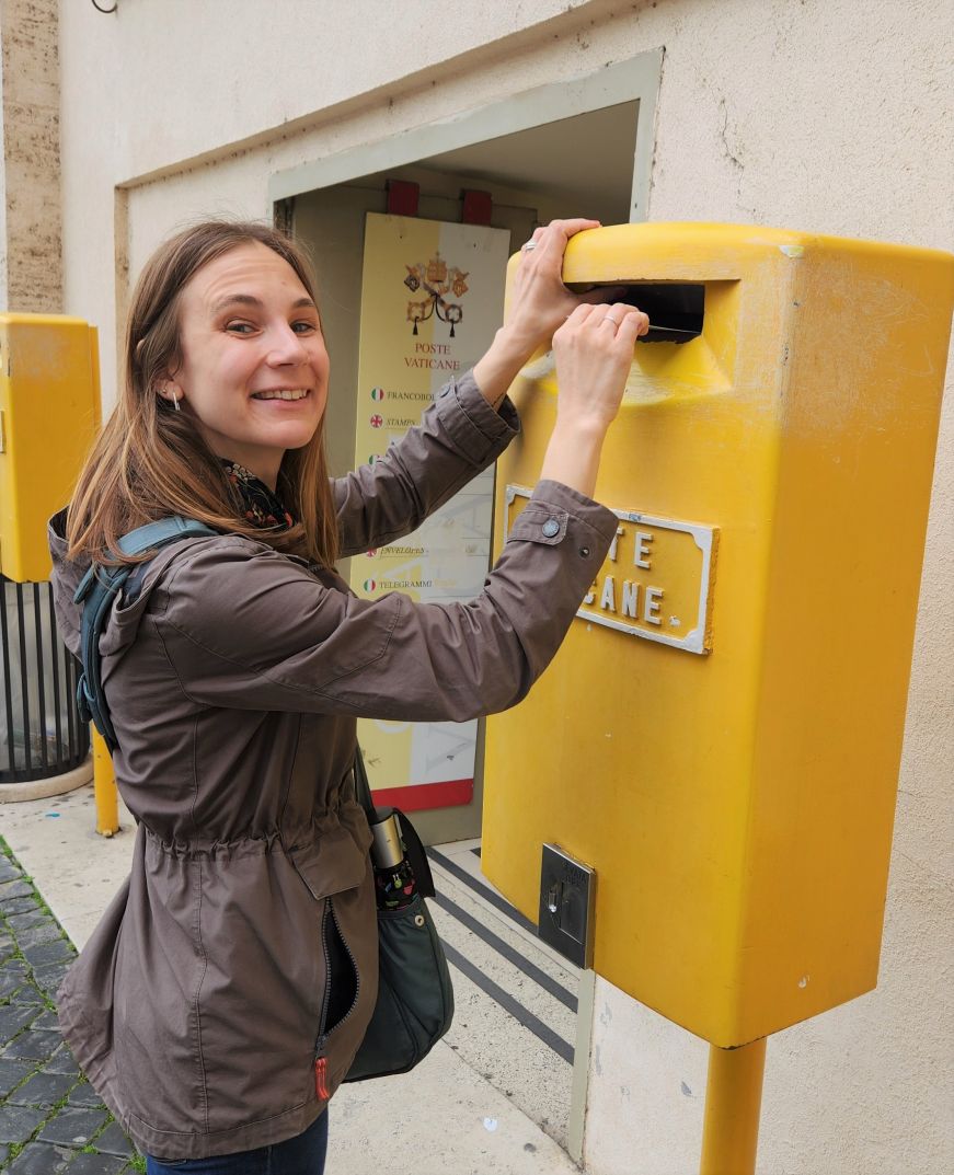 Stacy putting a postcard in a Vatican City post box