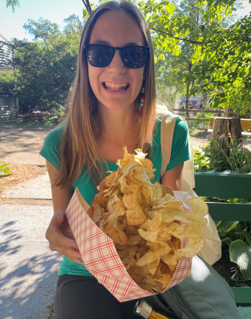 Stacy holding a large pile of deep-fried potato chips