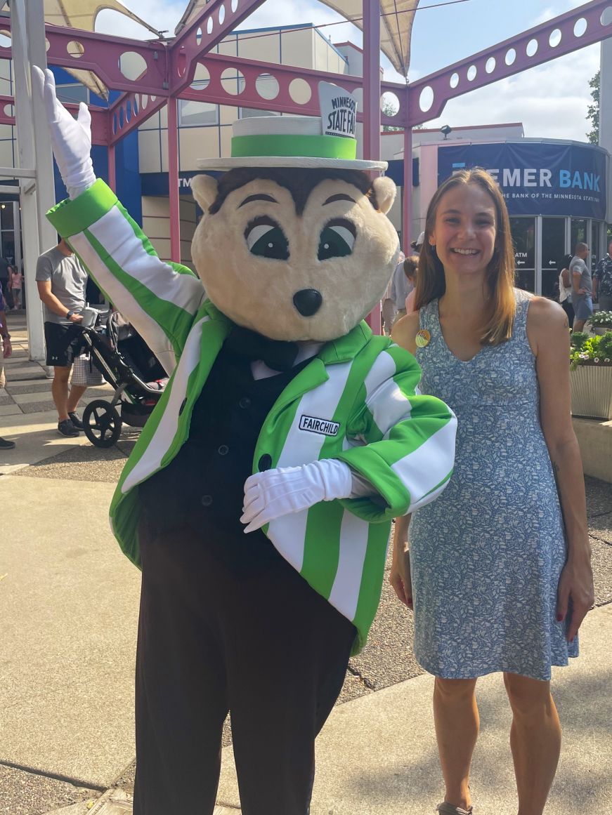 Stacy with Minnesota State Fair mascot Fairchild Stacy standing next to a costumed mascot