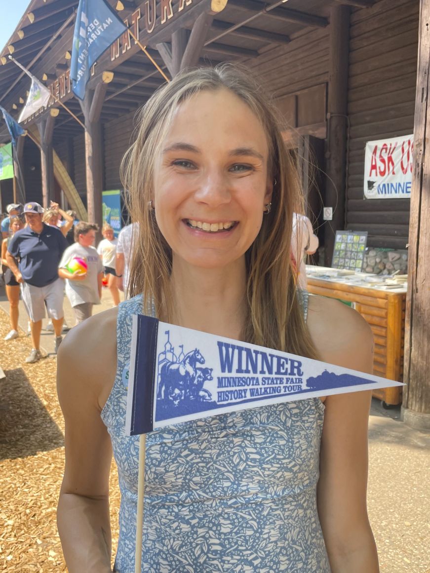 My 2023 prize from the Minnesota State Fair History Walking Tour Stacy holding a walking tour pennant