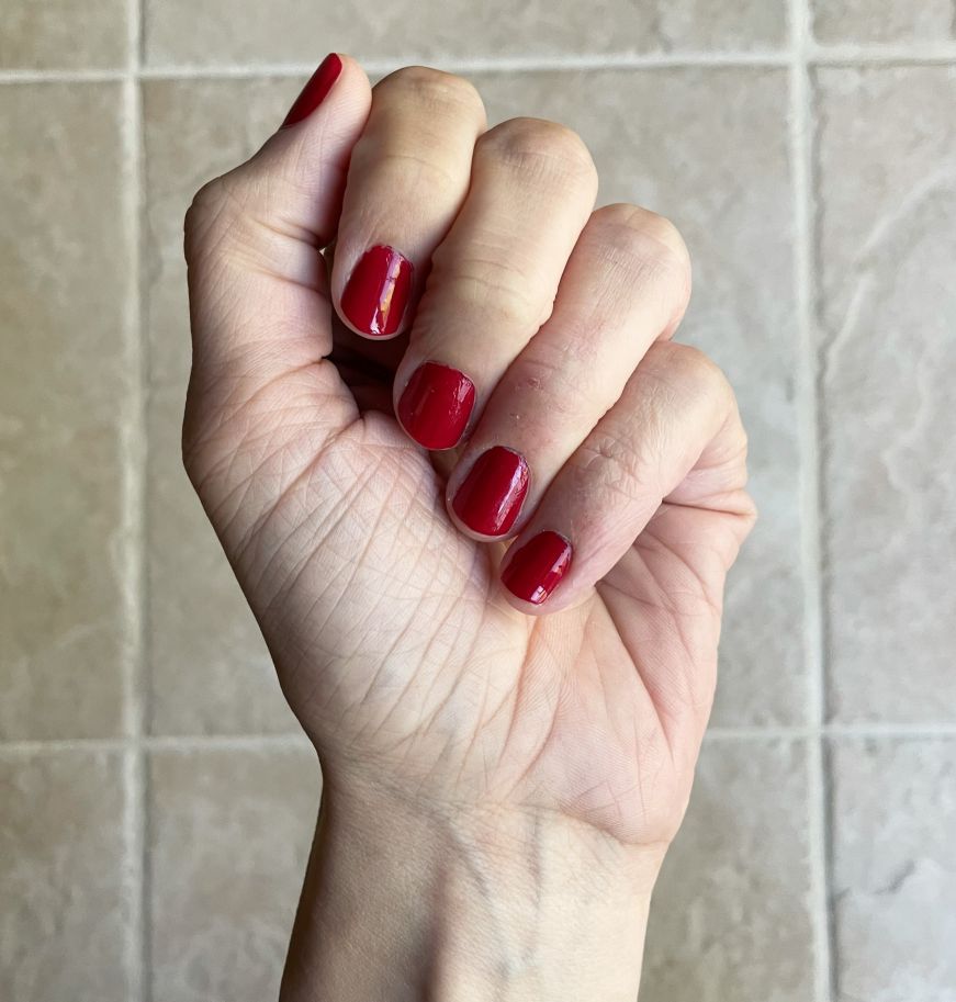 Stacy's hand with bright red nails