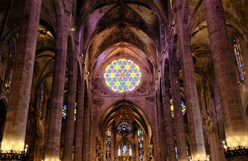 Interior of cathedral with a large, round, multi-colored stained glass window