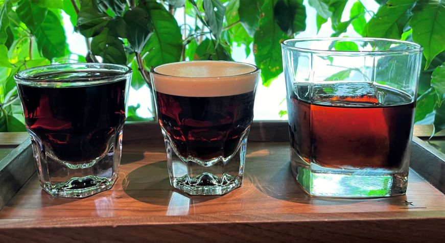 Wooden tray with three small glasses filled with cold brew coffee