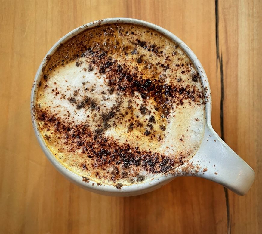 Coffee drink garnished with stripes of cacao powder