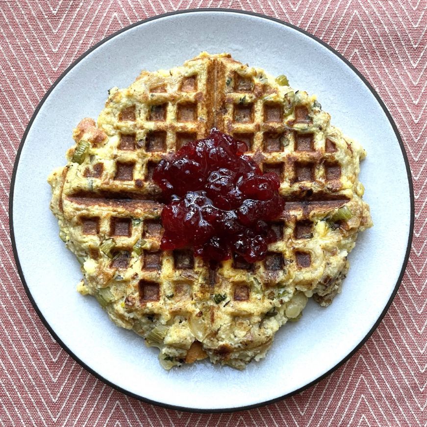 Stuffing waffle on 8.5" Coupe salad plate Stuffing waffle topped with cranberry sauce on a white plate with a brown edge