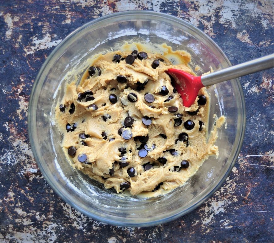 Chocolate chip cookie dough in a clear glass bowl