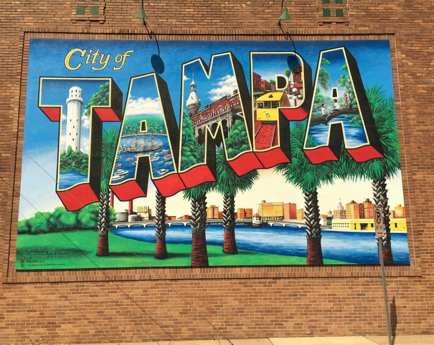 Mural of palm trees on brick wall with text reading "City of Tampa"