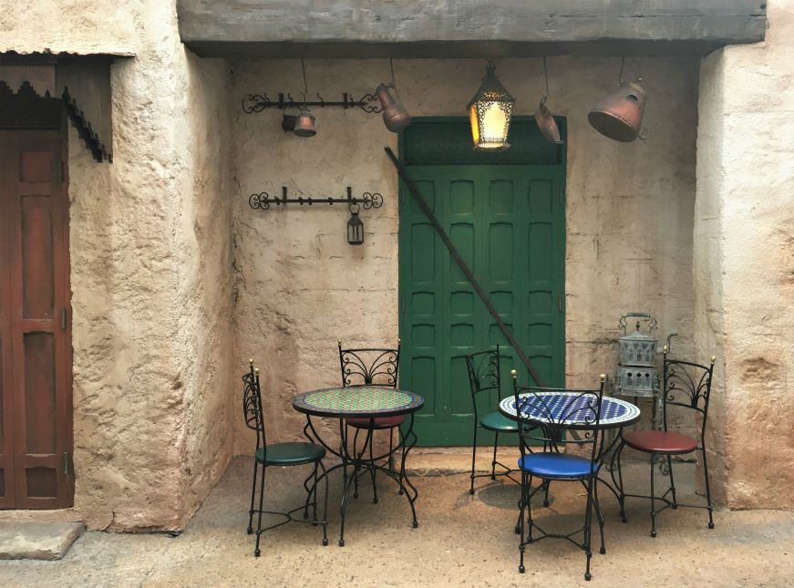 Tangierine Cafe, Morocco, Epcot Tables decorated with mosaics beside a stone builing, Tangierine Cafe, Morocco, Epcot