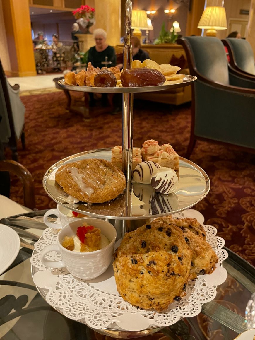 Three-tiered tea tower with scones, miniature desserts, nuts, and dried fruit