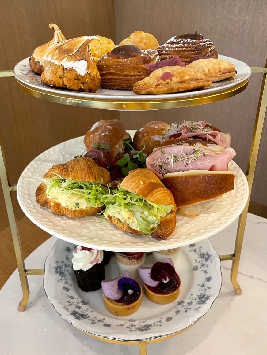 Three-tiered tea tower with scones, finger sandwiches, and pastries