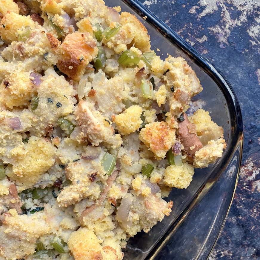 Top down view of stuffing made with white bread and corn bread in a glass baking dish
