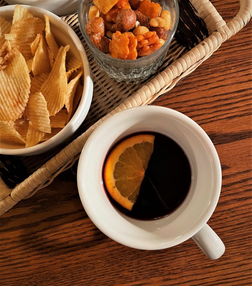 Bowls of chips and a mug of glogg garnished with an orange slice