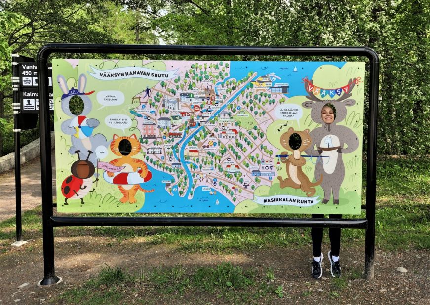 Vääksy map sign Pictorial map sign with cartoon animals and cutouts for heads