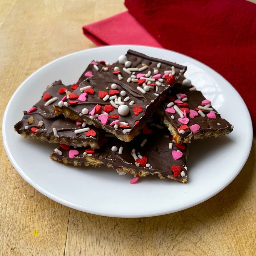 Pretzel bark decorated with Valentine's sprinkles on a white plate