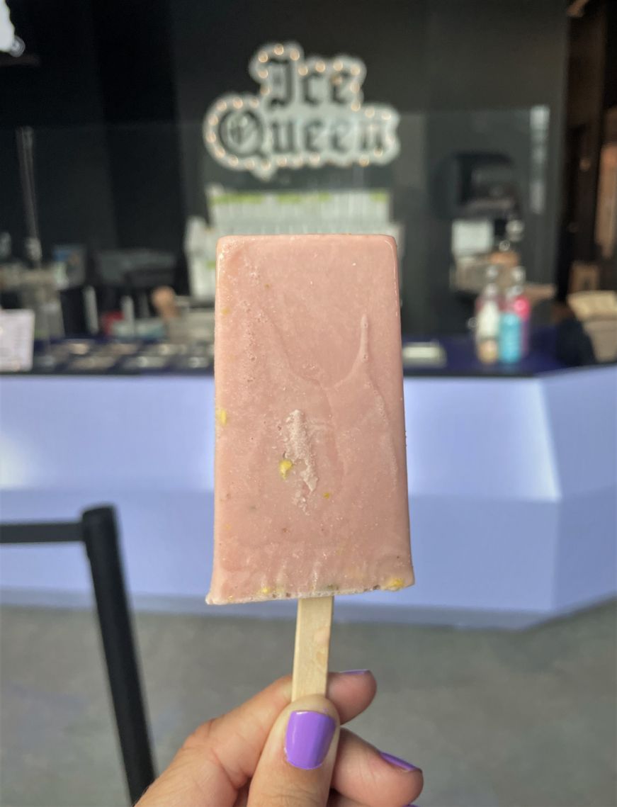 Vanilla rose pistachio paleta, Ice Queen Stacy's hand holding a light pink paleta