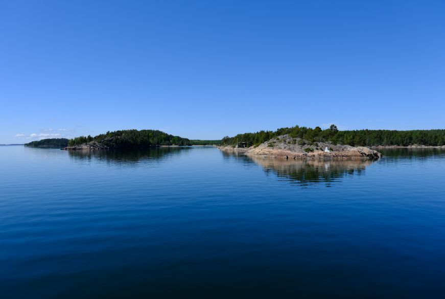 Blue water with islands covered with pine trees
