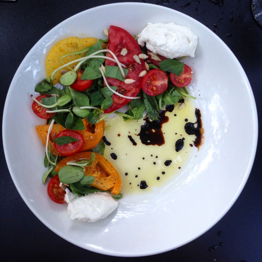 Elegantly plated sliced tomatoes drizzled with balsamic vinegar