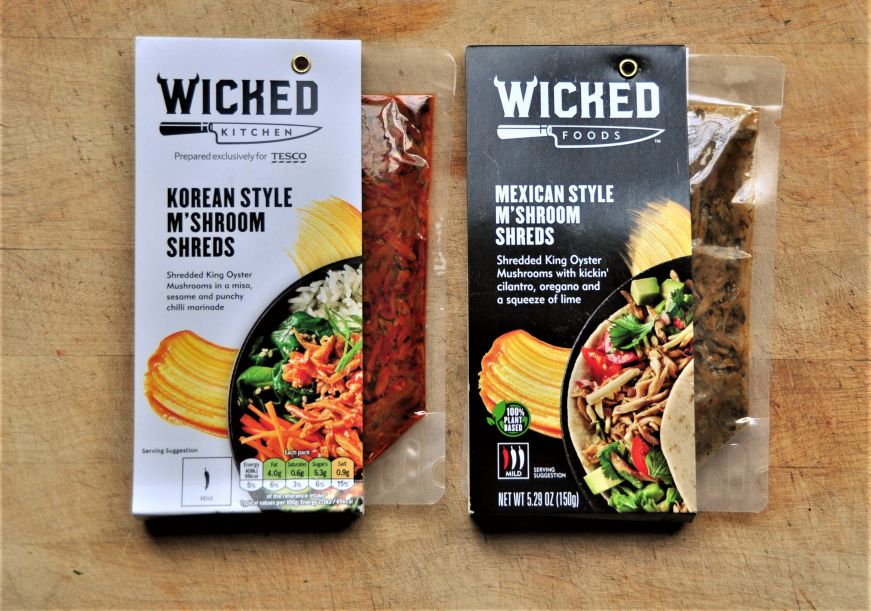 Two packages of shredded mushrooms, one labeled Mexican Style and the other labeled Korean Style