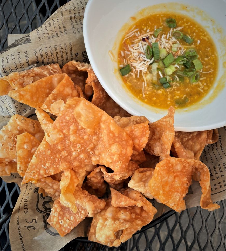 Basket of wonton chips with a bowl of mango salsa