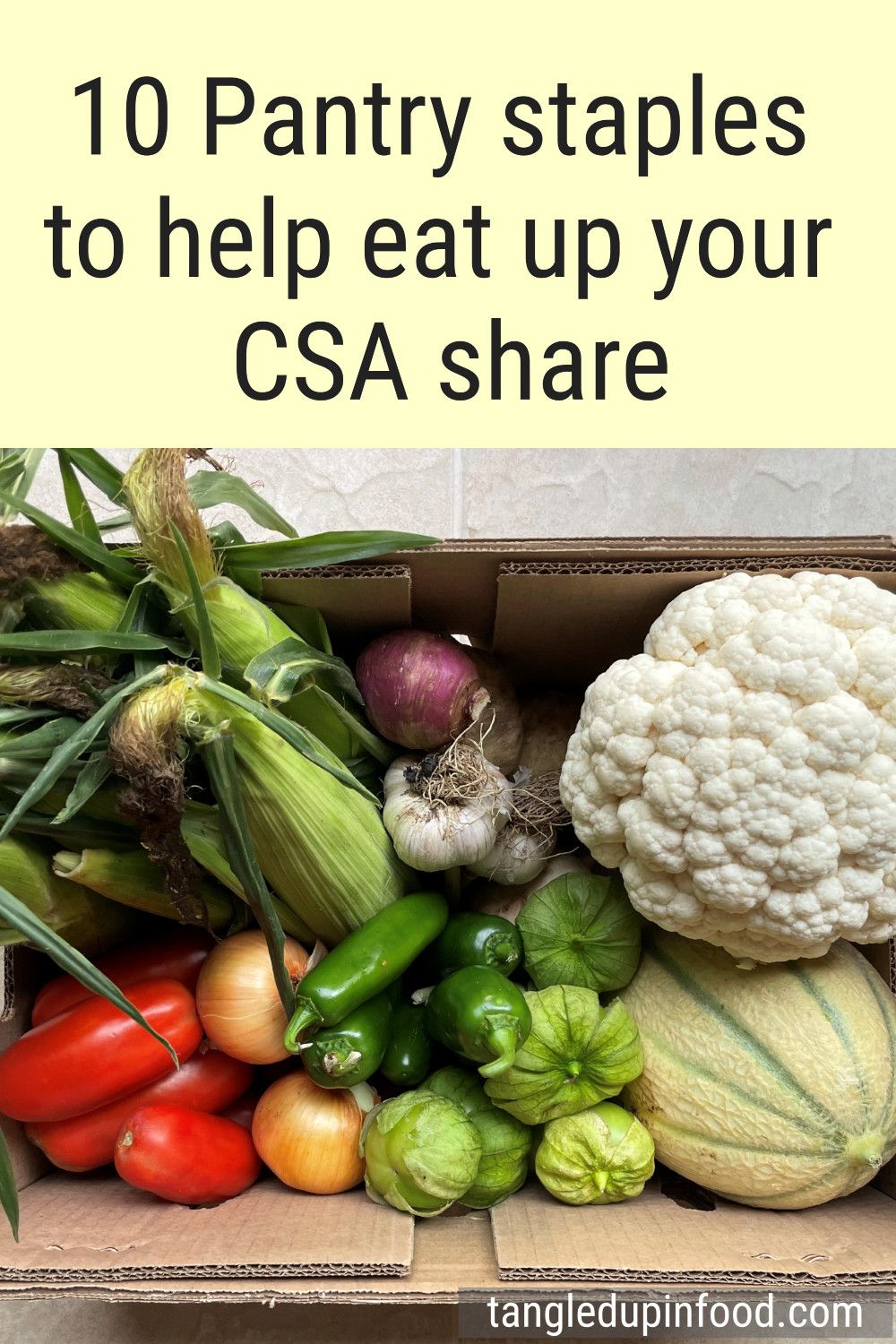 Cardboard box filled with produce and text reading "10 pantry staples to help eat up your CSA share"