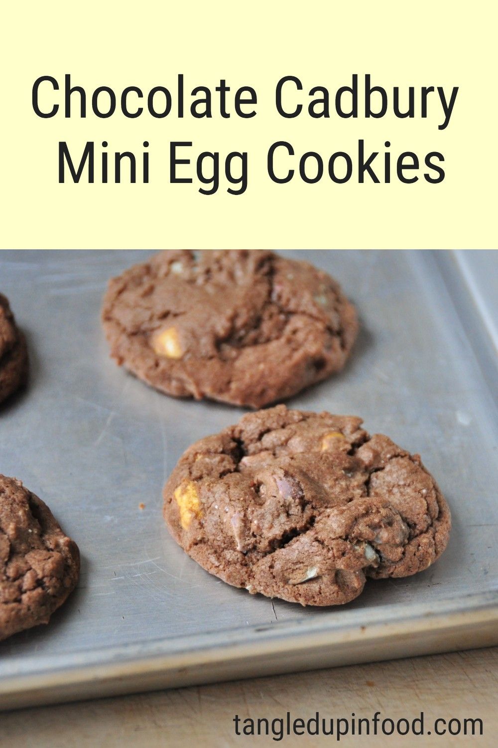 Cookies on baking sheet with text reading "Chocolate Cadbury Mini Egg Cookies"
