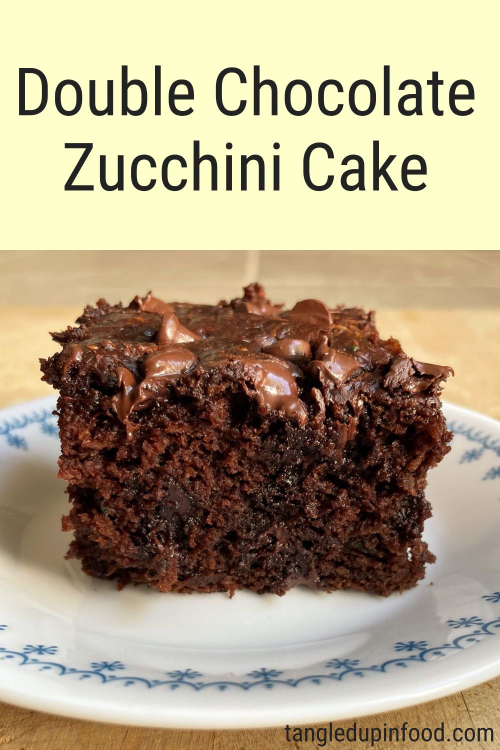 Piece of chocolate cake on plate with text reading "Double Chocolate Zucchini Cake"