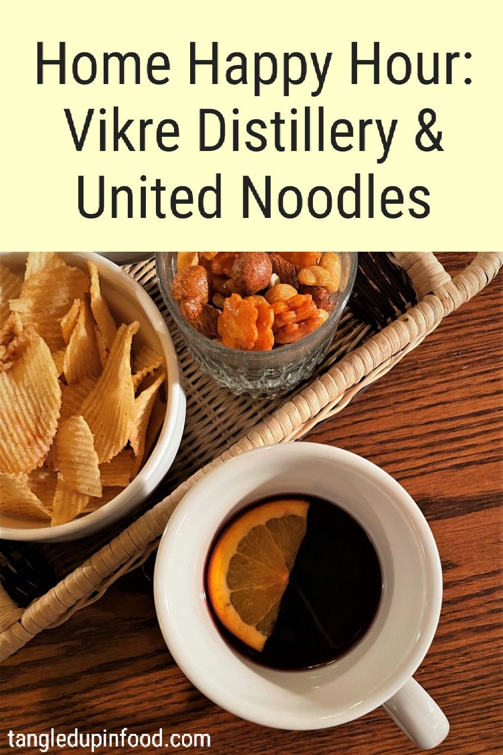 Mug of glogg cocktail and bowls of chips with text reading "Home Happy Hour: Vikre Distillery & United Noodles"
