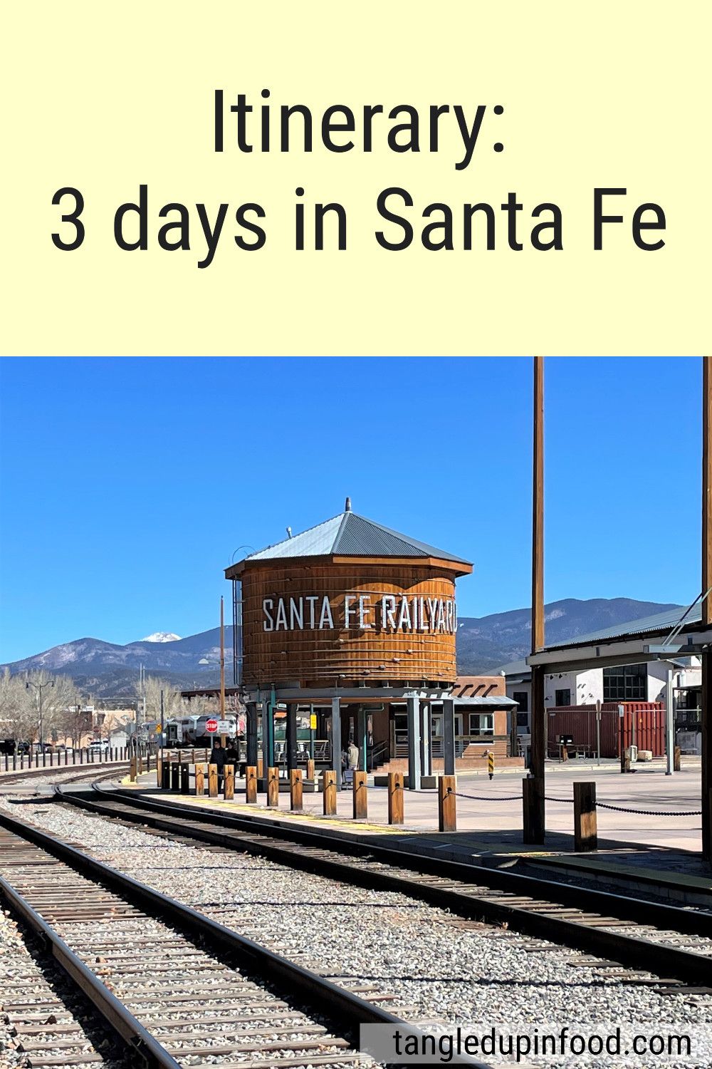 Water tower with blue sky and mountains in the background and text reading "Itinerary: 3 days in Santa Fe"