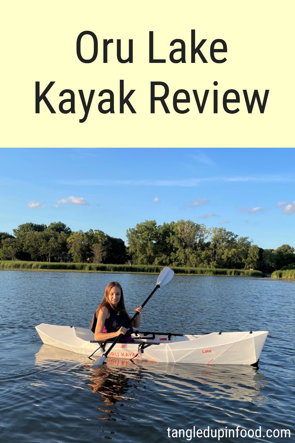 Photo of Stacy in a kayak with text reading "Oru Lake Kayak Review"