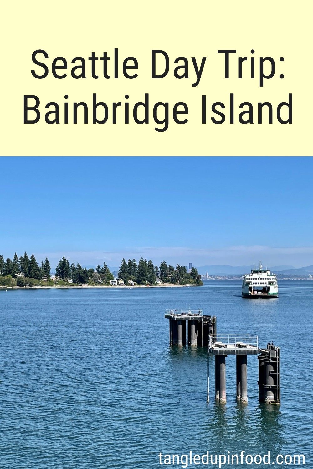 Forested shoreline with ferry in the distance and text reading "Seattle Day Trip: Bainbridge Island"