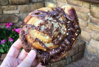 Hand holding pastry drizzled with Nutella