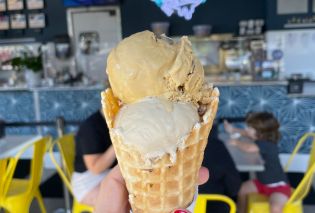 Stacy's hand holding a double scoop ice cream cone